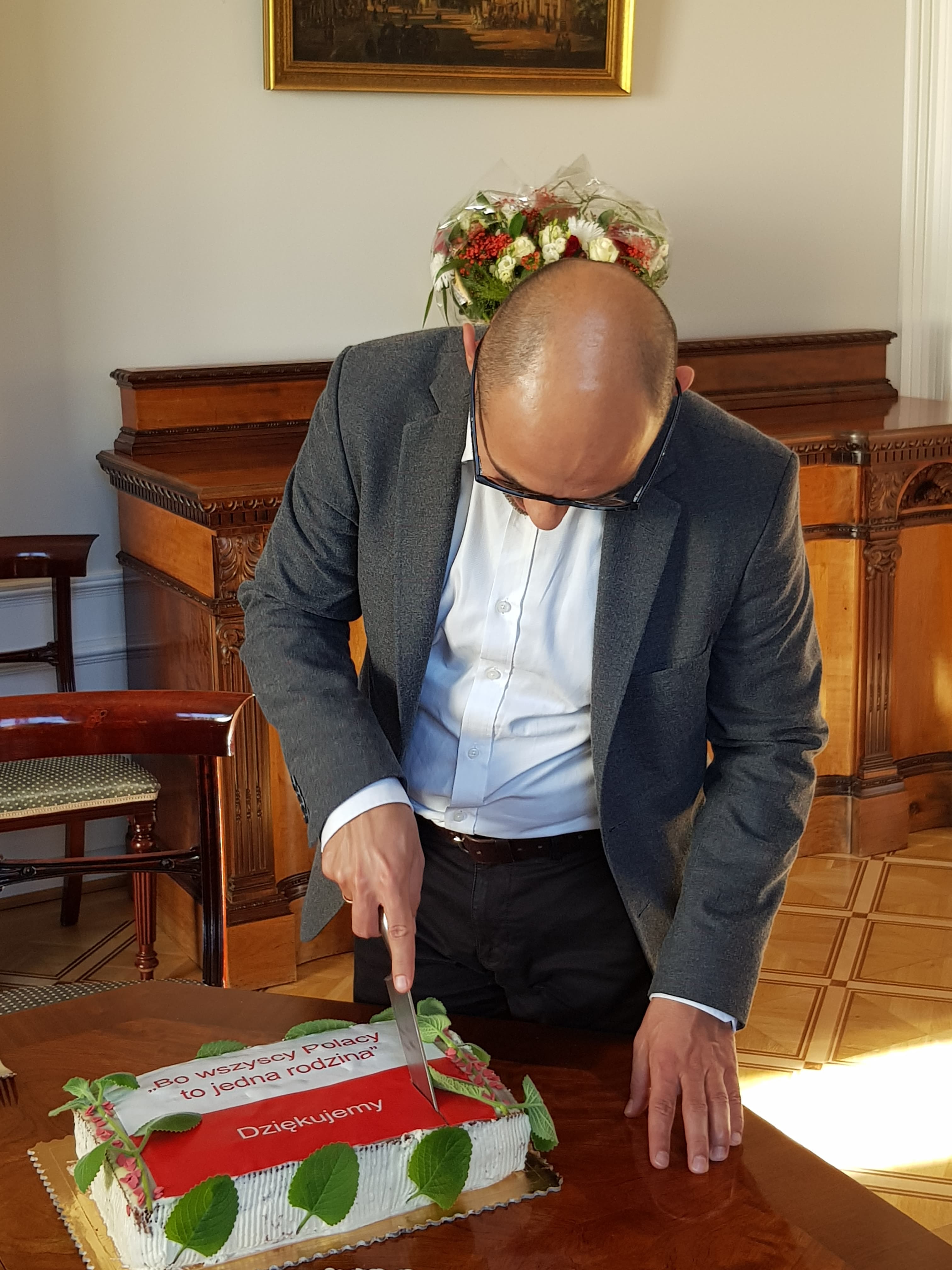 Pan Ambasador kroi biało-czerwony tort